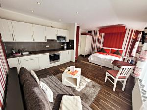 - un salon avec un canapé et un lit dans une chambre dans l'établissement Ferienwohnungen "Yvonne Zacher-Schult", à Kühlungsborn