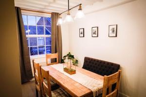 a dining room table and chairs with a window at The Wine Loft in Quorndon