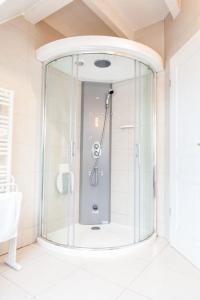 La salle de bains est pourvue d'une douche et d'une porte en verre. dans l'établissement Doller Villa 4 stars Hot Tub Mountain Ski Ballon d'Alsace, à Sewen