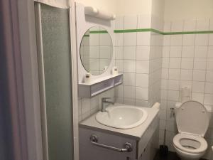 a bathroom with a sink and a toilet and a mirror at Le village Gr34 in Louannec