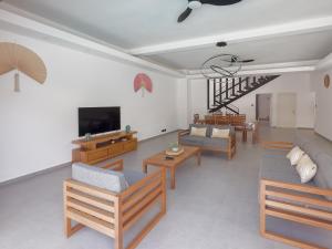 uma sala de estar com um sofá e cadeiras e uma televisão em Résidence Mo'Villa - Spacious 4 Bedrooms Villa with infinity pool em Grand Baie