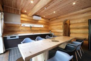 a dining room with a large wooden table and chairs at 一度だけでも体験してほしいイエローシーダーハンドカットカナディアンログハウス in Karuizawa