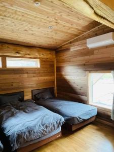 a bedroom with a bed in a wooden cabin at 一度だけでも体験してほしいイエローシーダーハンドカットカナディアンログハウス in Karuizawa