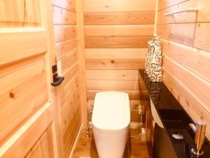 a bathroom with a toilet in a wooden cabin at 一度だけでも体験してほしいイエローシーダーハンドカットカナディアンログハウス in Karuizawa