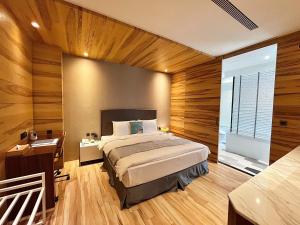 1 dormitorio con cama, escritorio y ventana en Vasty Jiaoxi Hotel, en Jiaoxi