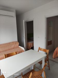 Villaggio Welcome Riviera d'Abruzzo في تورتوريتو ليدو: غرفة معيشة مع طاولة وكراسي بيضاء