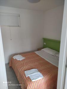 Villaggio Welcome Riviera d'Abruzzo في تورتوريتو ليدو: غرفة نوم عليها سرير وفوط