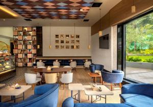 un restaurante con muebles azules, mesas y sillas en O by Tamara Coimbatore en Coimbatore