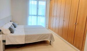 1 dormitorio con 1 cama y armarios de madera en BEACH VALENCIA 29 - Luxury Beachfront Apartament, en Valencia