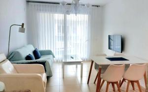 salon z łóżkiem, stołem i krzesłami w obiekcie BEACH VALENCIA 29 - Luxury Beachfront Apartament w Walencji