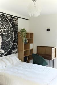 a bedroom with a white bed and a desk at Rose Blossom apartment in Paris in Vanves