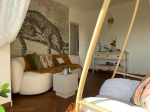 a living room with a couch and a hanging bed at Rose Blossom apartment in Paris in Vanves