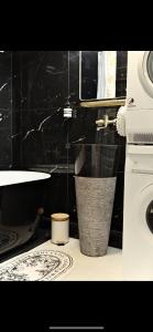 a bathroom with a sink and a trash can at Rose Blossom apartment in Paris in Vanves