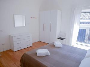 um quarto com uma cama, uma cómoda e uma janela em Ai banchi Apartment em Catânia