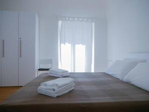 um quarto com toalhas brancas numa cama com uma janela em Ai banchi Apartment em Catânia