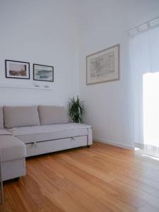 uma sala de estar com um sofá e um piso de madeira em Ai banchi Apartment em Catânia