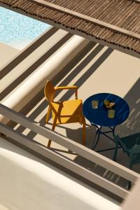 a yellow chair and a table and a blue chair at Isychos House in Mikri Vigla