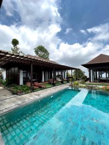 a swimming pool in front of a villa at Shankara Munduk Bali in Munduk