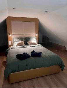 Un dormitorio con una cama grande con dos bolsas. en Gite le3chênes, en Remoncourt