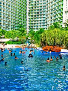 eine Gruppe von Personen, die in einem Pool in einem Resort schwimmen in der Unterkunft Azure Stay by Marjorenz in Manila