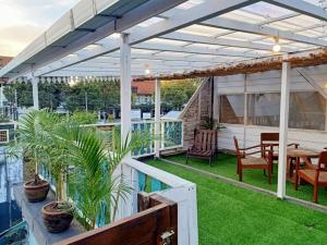 a pergola over a patio with a table and chairs at The Blue Joglo Jogja in Yogyakarta