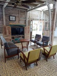 a living room with several chairs and a television at The Blue Joglo Jogja in Yogyakarta +30 photos