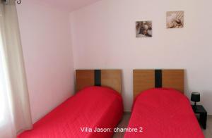 two beds in a room with red sheets at Jason in Cervione +20 photos