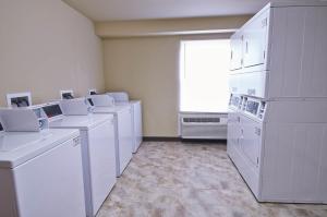 プレザントンにあるSavannah Suites Pleasantonの白い家電製品と窓付きのランドリールーム
