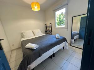 um quarto com uma cama, um espelho e uma janela em Charmant Appartement Terrasse, Calme et Confort em Avignon