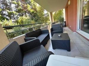 uma varanda com sofás e uma mesa na varanda em Charmant Appartement Terrasse, Calme et Confort em Avignon