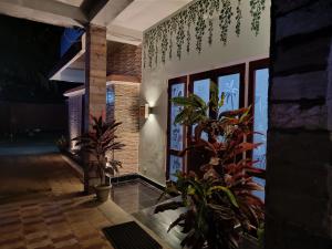 a house with plants in front of a door at Mulberry Guesthouse in Guwahati