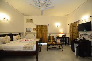 a bedroom with a bed and a desk and a television at Jaipur Vintage House in Jaipur