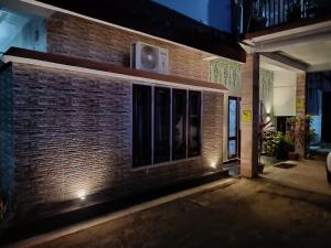 a brick building with windows at night at Mulberry Guesthouse in Guwahati