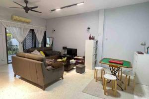 uma sala de estar com um sofá e uma mesa em 311 Nana’s Homes BBQ, Games, Netflix 11pax em Ampang