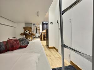 um urso de peluche sentado numa cama num quarto em Appartement 6 personnes avec Parking Couvert - 1 chambre - 4 lits - Netflix & wifi haut débit em Tignes