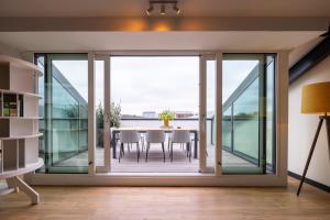 a dining room with sliding glass doors with a table and chairs at Plesman Residences in Scheveningen