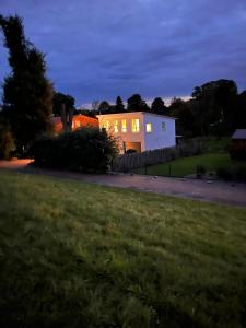 a house with lights on in a yard at night at Cottage an der Elbe Tespe Hamburg in Tespe