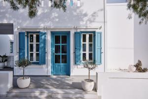 un edificio blanco con puertas y ventanas azules en Chrysalis Boutique - Adults Only, en Astipalea