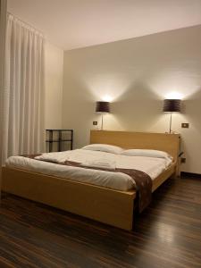 a bedroom with a large bed with two lamps at Appartamento Malpigihi 40 in Arezzo