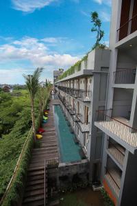 uma vista exterior de um edifício com piscina em FRii Bali Echo Beach em Canggu