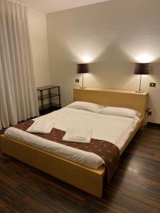 a large bed in a bedroom with two lamps at Malpighi 40 in Arezzo