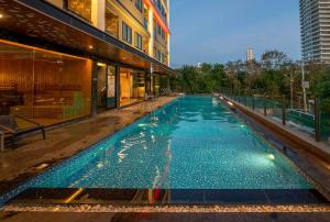 a swimming pool in the middle of a building at The TJ Hotel Jomtien in Jomtien Beach
