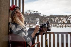 a woman sitting in a chair taking a picture with a camera at Aves Arosa in Arosa