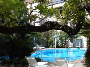 a view of the swimming pool at a hotel with chairs and trees at Tizi Apartments Corso Reginna in Maiori