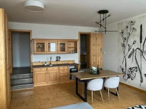 a kitchen with wooden cabinets and a wooden table and chairs at Apartmány Štěpánkova 85 in Chrudim