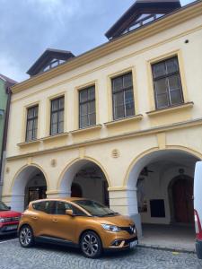 un coche naranja estacionado frente a un edificio en Apartmány Štěpánkova 85, en Chrudim