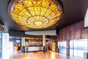 Rixwell Elefant Hotel في ريغا: بهو مع سقف زجاجي ملون كبير