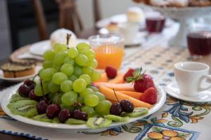 a plate of grapes and fruit on a table at Casa Dei Vettii B&B in Pompei Scavi