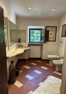 baño con aseo y lavabo y ventana en Molin Barletta - Nice Holiday House With Private Pool Marliana, Toscana en Marliana