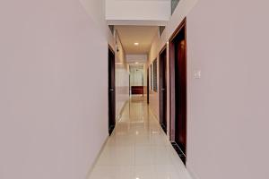 a corridor in a house with white floors and a hallway at Super Collection O Emara Grand Mysore in Mysore